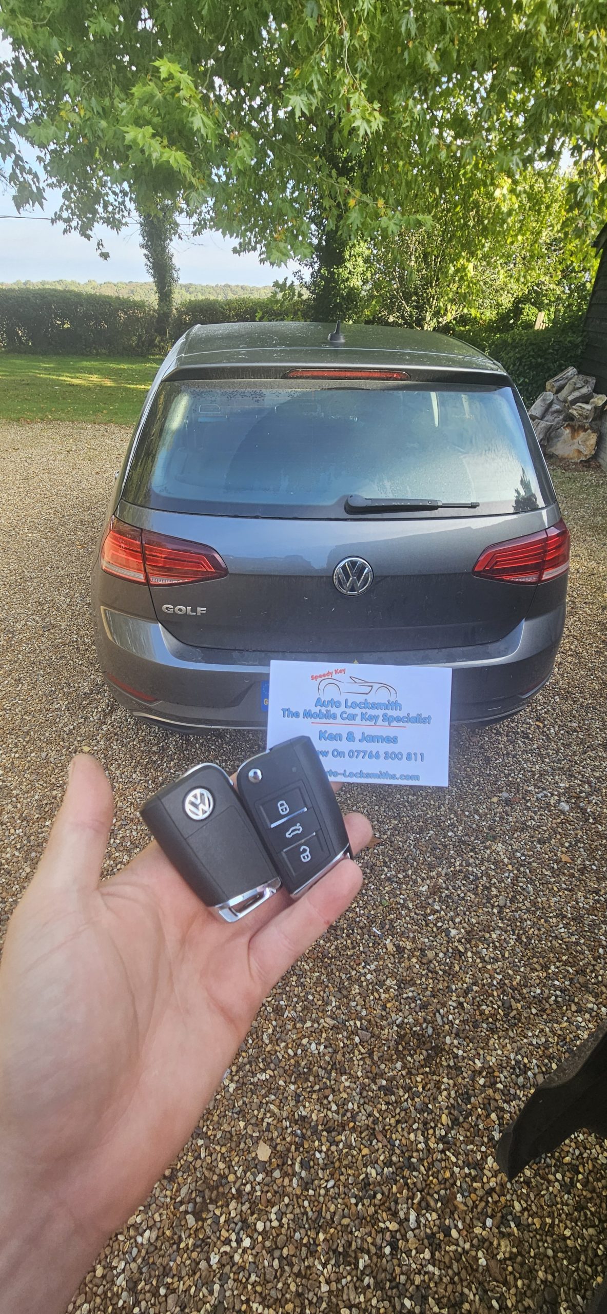 car replacement key held up to a car near fields in hertfordshire